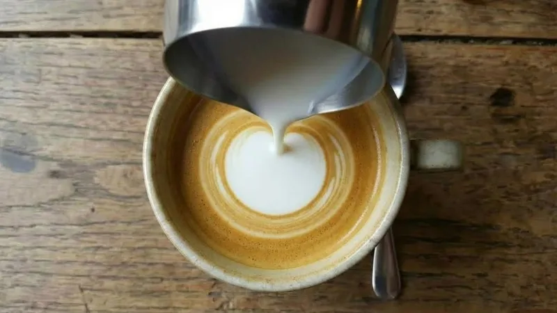 Overhead view of the white Monk's Head circle expanding symmetrically as the pour continues at a steady rate and low height