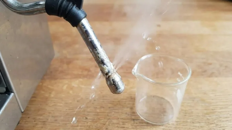 Breville steam wand showing weak and uneven steam flow caused by partial blockage from dried milk residue